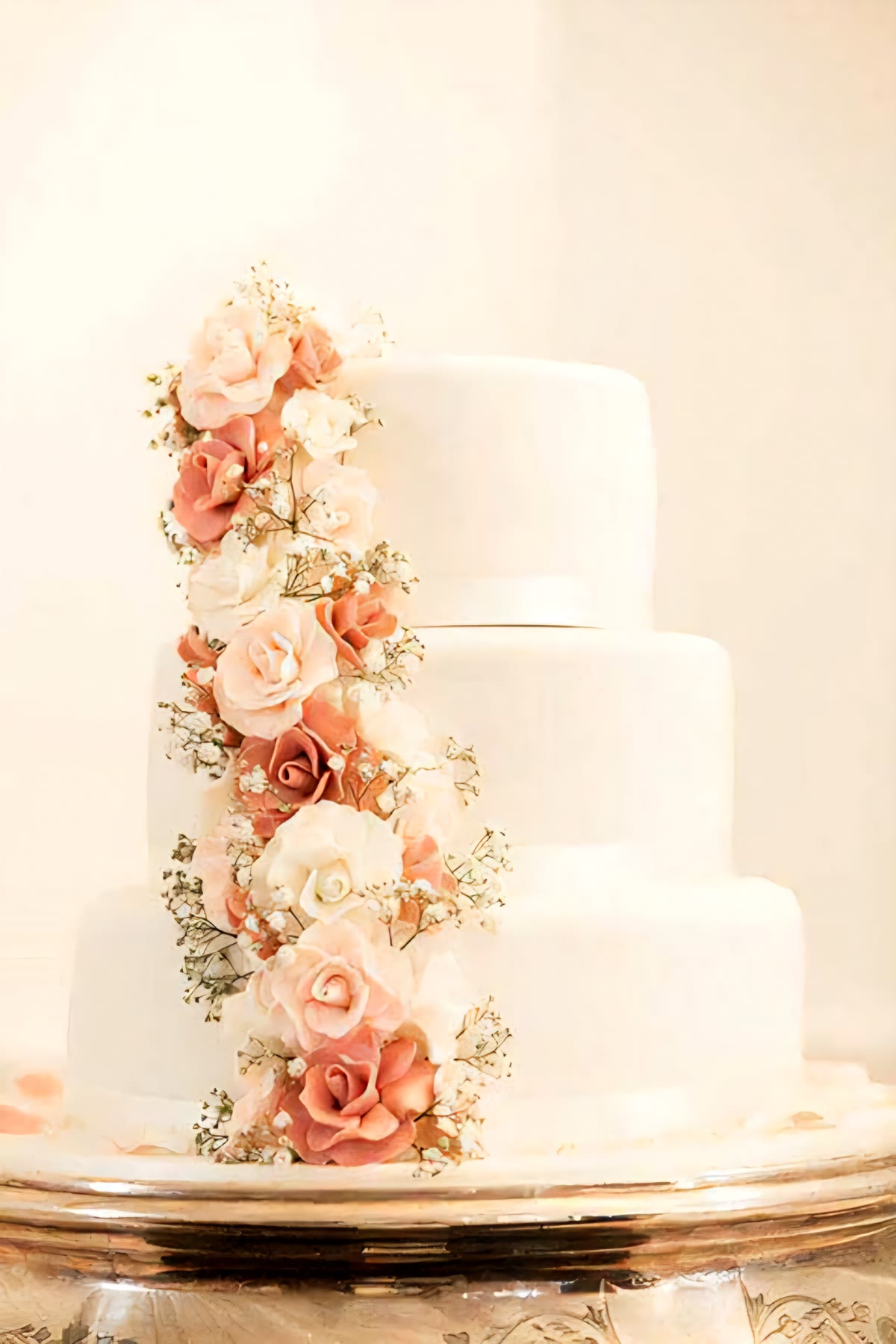 Soft ivory wedding cake with blush sugar flowers